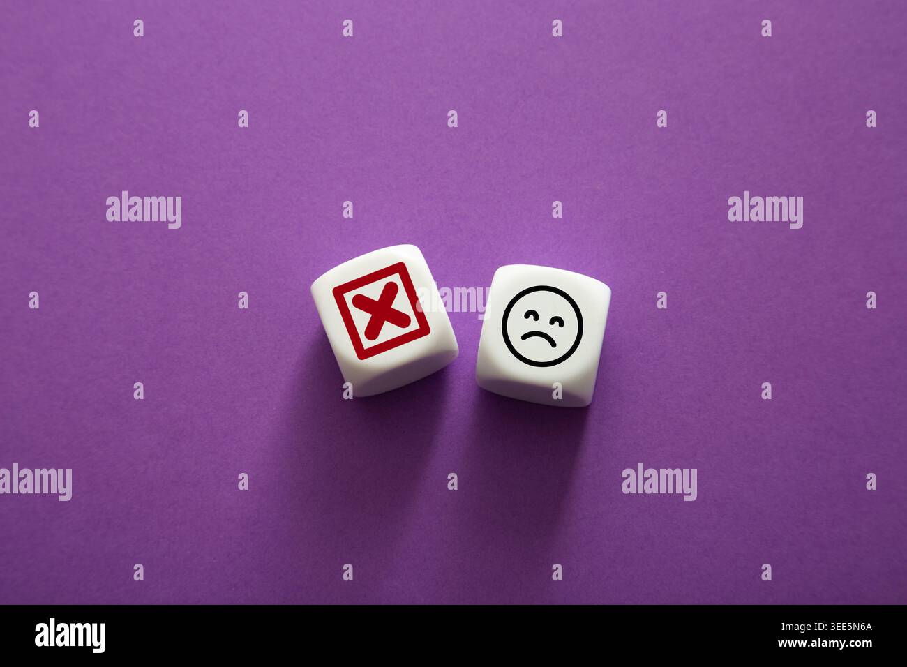 Zwei Würfel auf violettem Hintergrund für negatives Feedback und Unzufriedenheit Stockfoto