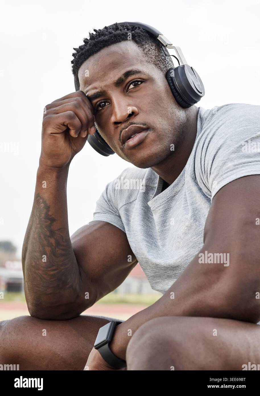 Kopfhörer, Think und müde Mann im Freien für Fitness mit Audio, Ruhe und Radio hören. Musik, Schwarze oder Sportler auf Pause in der Natur mit Stockfoto