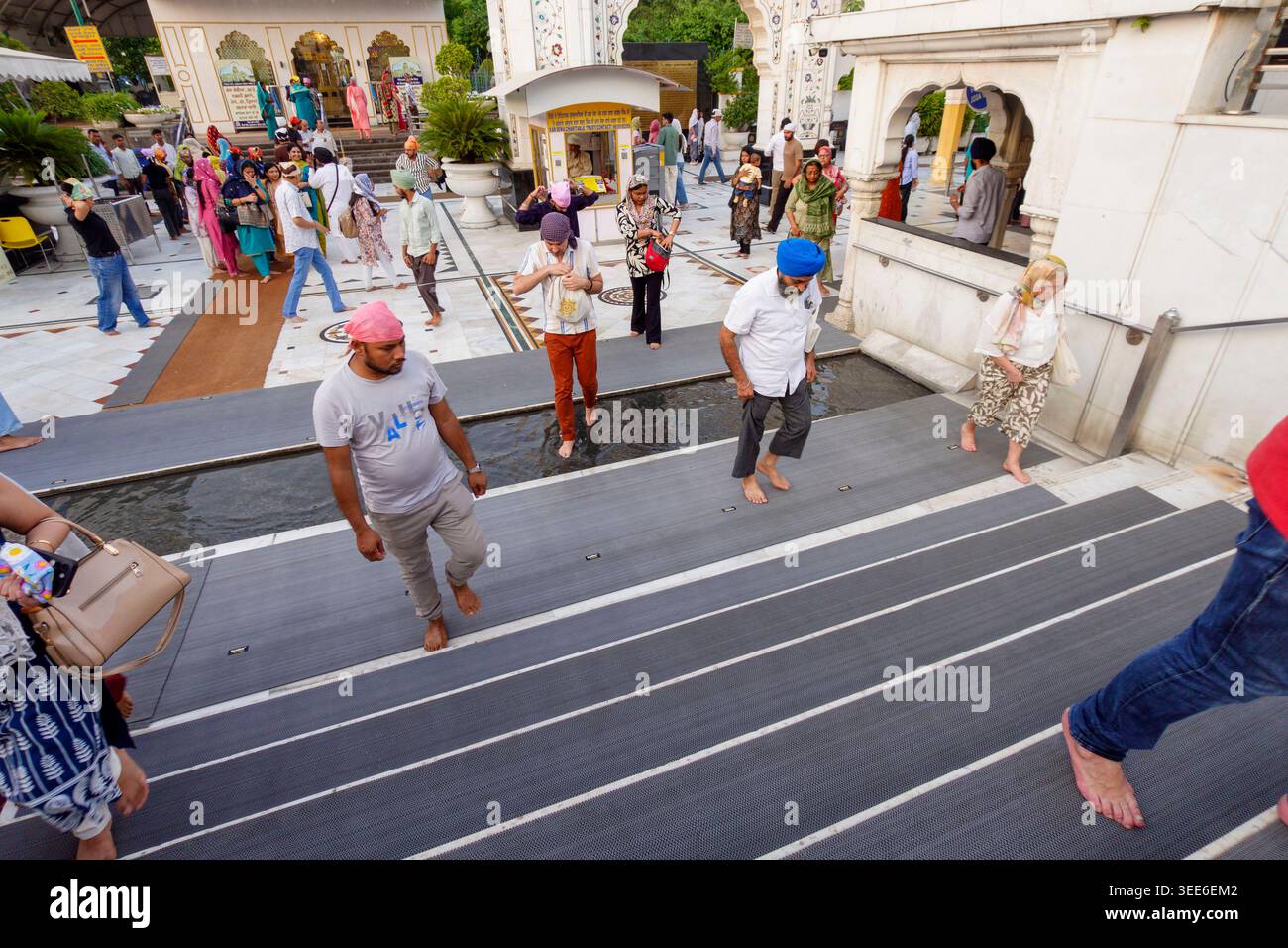 Menschenmenge und Besucher betreten den historischen Gurdwara Bangla Sahib sikh Tempelkomplex mit seiner weißen Marmorarchitektur in Neu-Delhi Indien Stockfoto