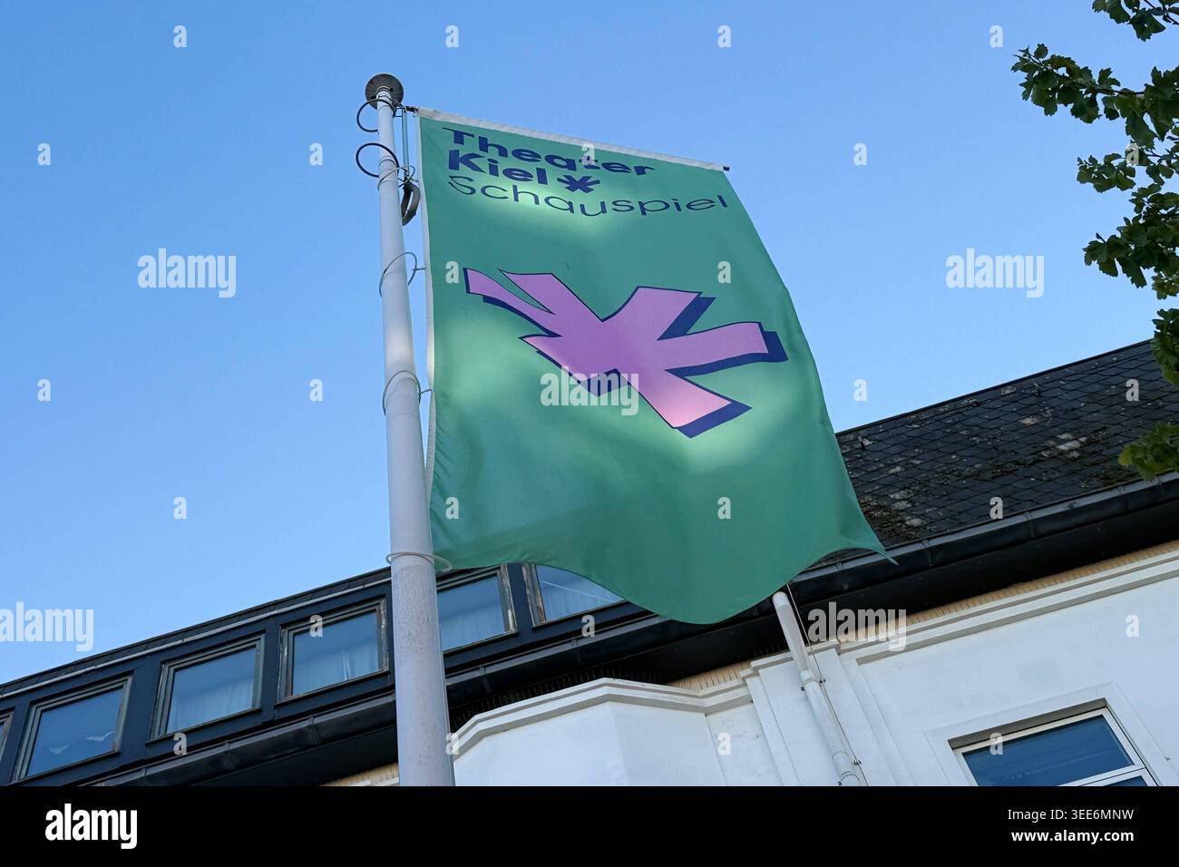 Schauspielhaus Kiel Kiel, Deutschland - 8,5.2026: Eine Flagge weht vor dem Schauspielhaus während Besucher das Kieler Schauspielhaus betreten vor einer Vorstellung. Schleswig-Holstein Stockfoto