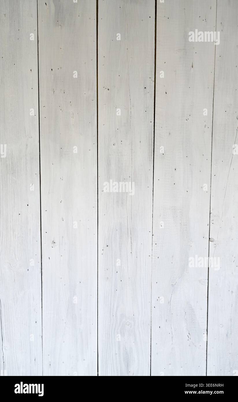 Verwitterte, weiß gewaschene Plattenoberfläche mit vertikalen Platten, die abgenutzte Farbe zeigen und die Holzstruktur sichtbar machen Stockfoto