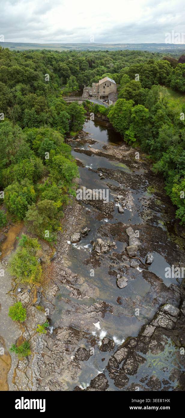 Luftvertorama des Flusses ure schlängelt sich durch felsige Stromschnellen vorbei an Aysgarth Mill und dichten Wäldern Stockfoto