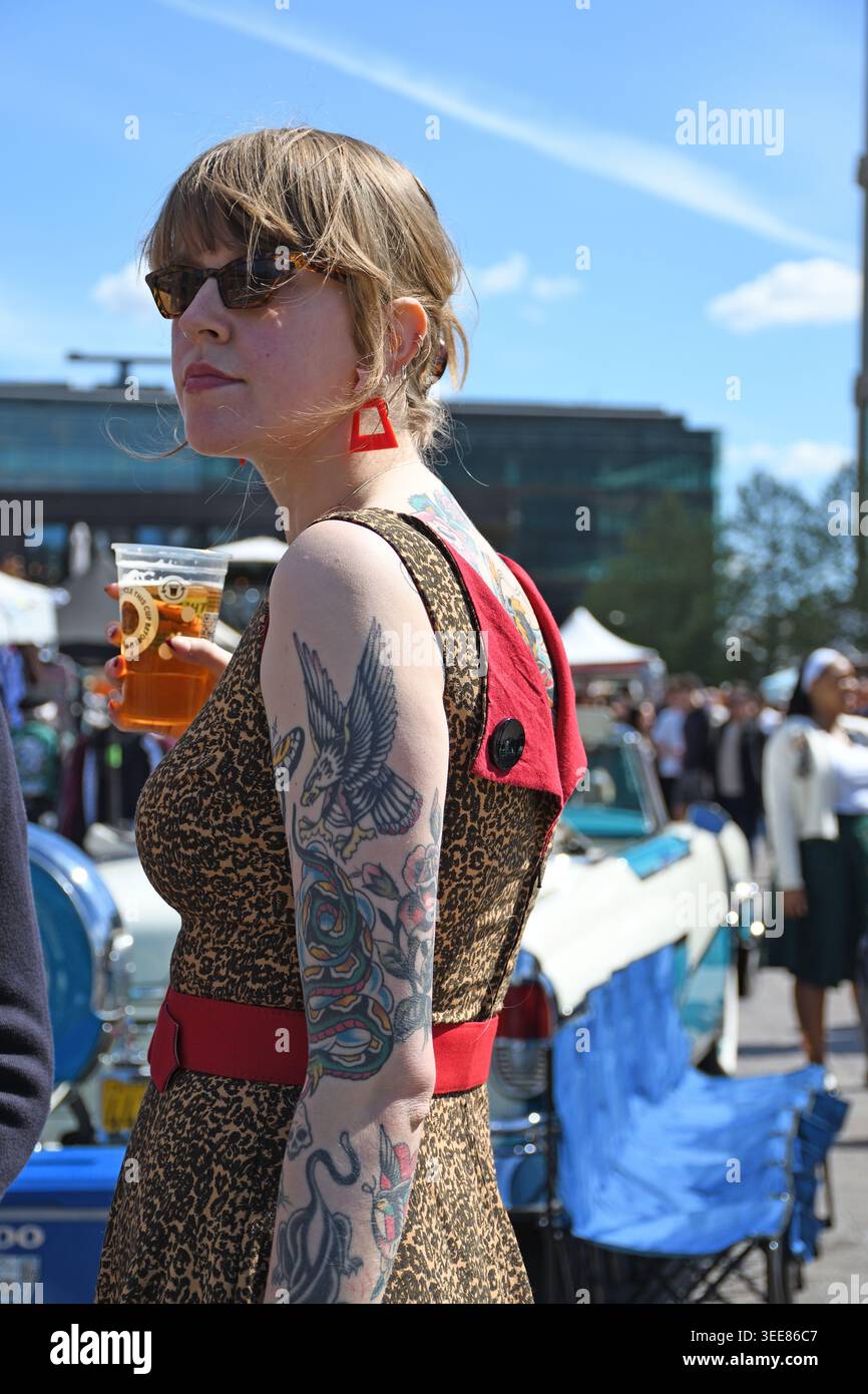 Frau mit Tätowierungen, Verkauf von Oldtimer-Stiefeln, King's Cross, London, England, Vereinigtes Königreich Stockfoto