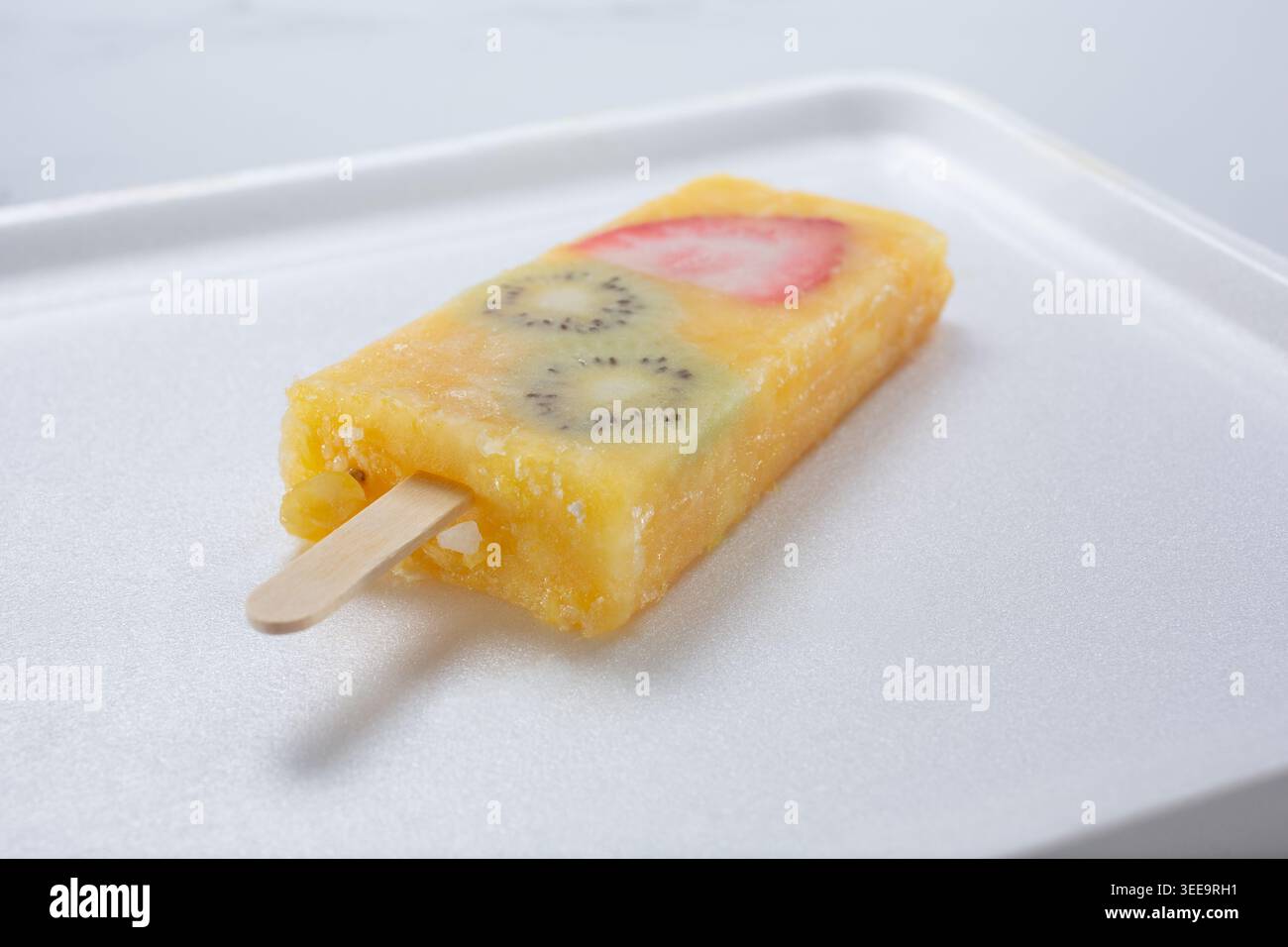 Blick auf eine Ananasorange Mango paleta mit Kiwi- und Erdbeerscheiben. Stockfoto
