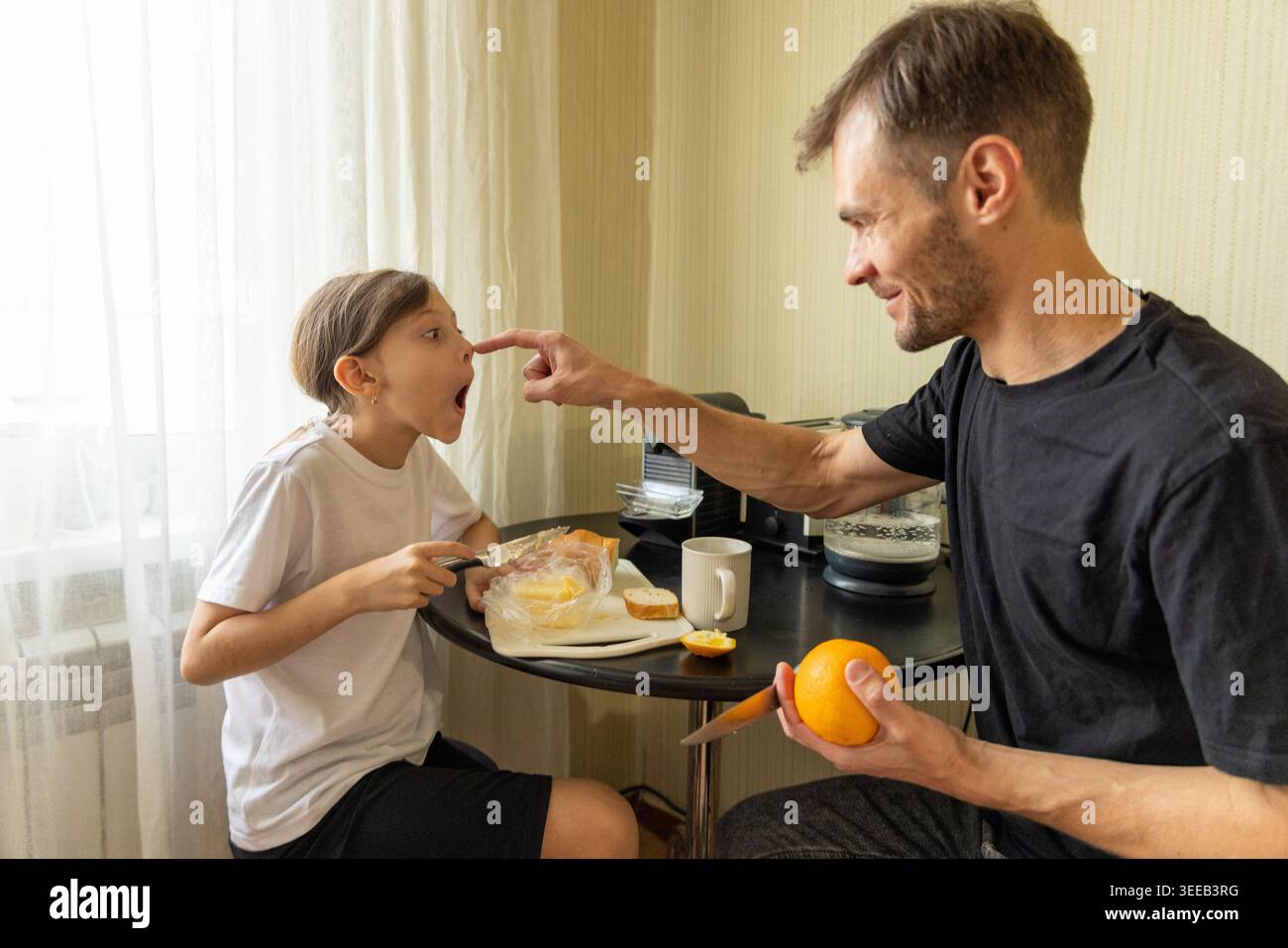 Vater spielt mit Tochter beim Frühstück Stockfoto