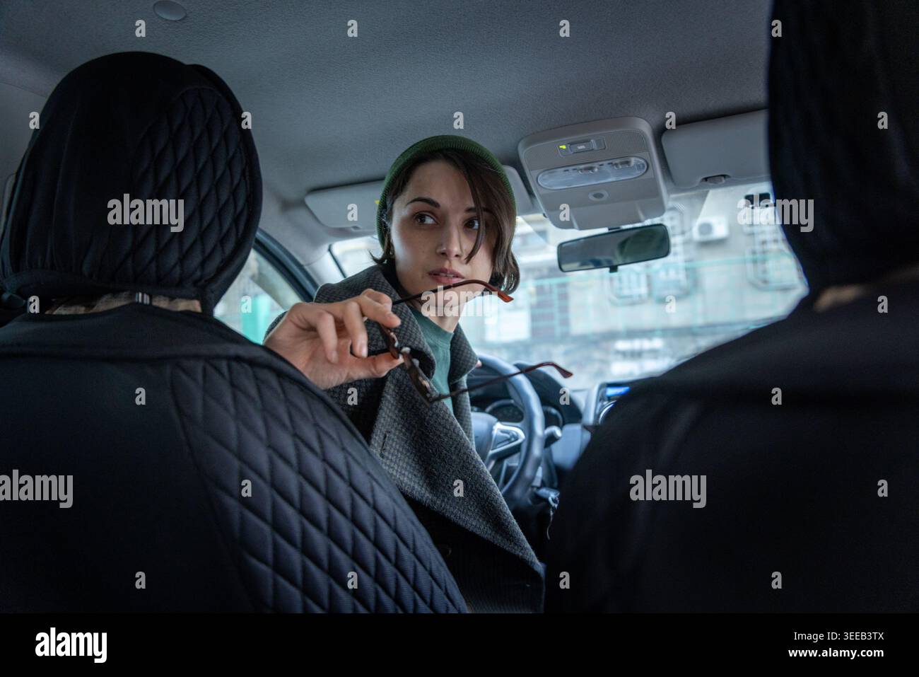 Frau, die vom Fahrersitz aus mit den Passagieren spricht Stockfoto