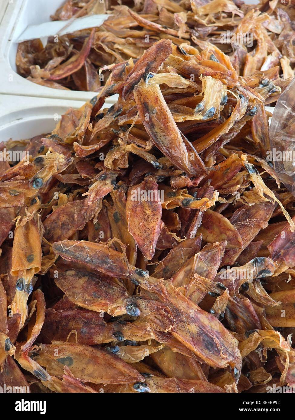 Appetitlicher Snack auf dem Markt für getrocknete Tintenfische, Meeresfrüchte, traditionelle braune Zutaten, Meer, das authentische Street Food-Erlebnis für kulinarischen Geschmack und bietet Stockfoto