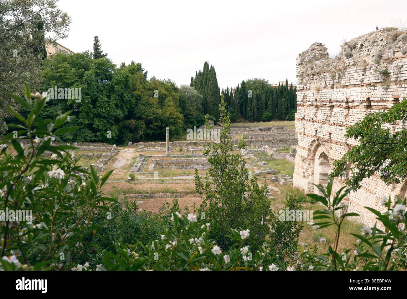 Antike römische Ruinen mit Steinmauern und Säulen in grüner mediterraner Landschaft. Historische archäologische Stätte mit antiken Überresten Stockfoto