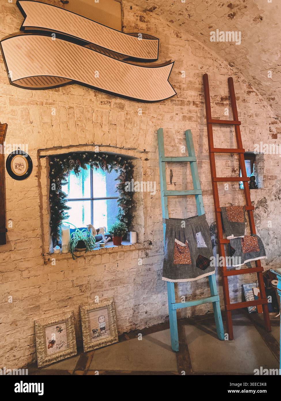 Gemütliches Kunsthandwerkszimmer mit Einrichtung und Fenster, warmes Licht, rustikale Lifestyle-Szene - Smartphone-aufgenommenes Stockfoto