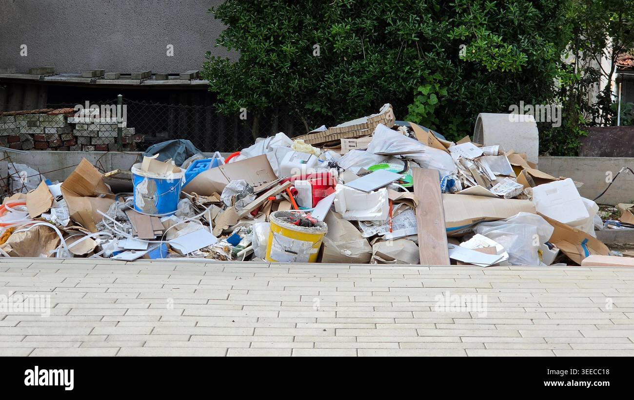 Ein großer Haufen von weggeworfenen Baumaterialien, einschließlich Pappe, Kunststoffeimer, Holzreste und Styropor, zur Entsorgung zusammengestellte Sitze Stockfoto