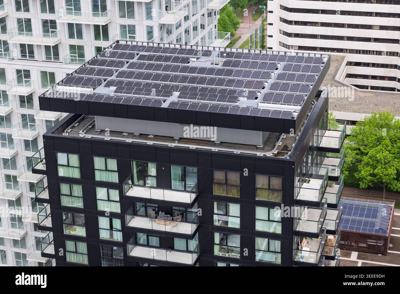 Amsterdam, Niederlande, 08. Mai 2026. Luftaufnahme eines großen Photovoltaik-Solarpaneels, das auf dem Dach eines schwarzen Wohnhochhauses installiert ist Stockfoto