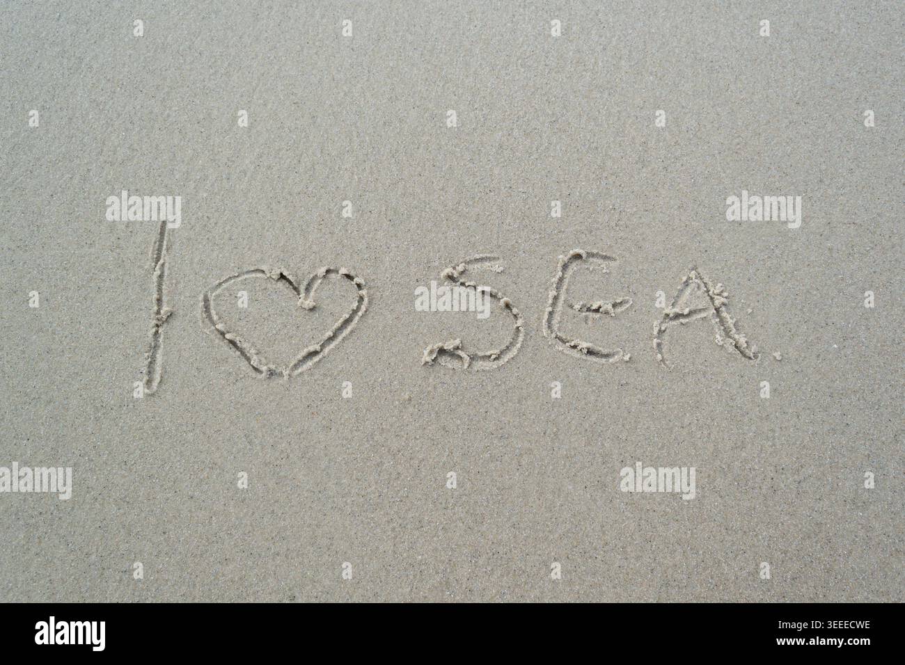 Ich liebe das handgeschriebene Meer auf Sandstrand Hintergrund Stockfoto