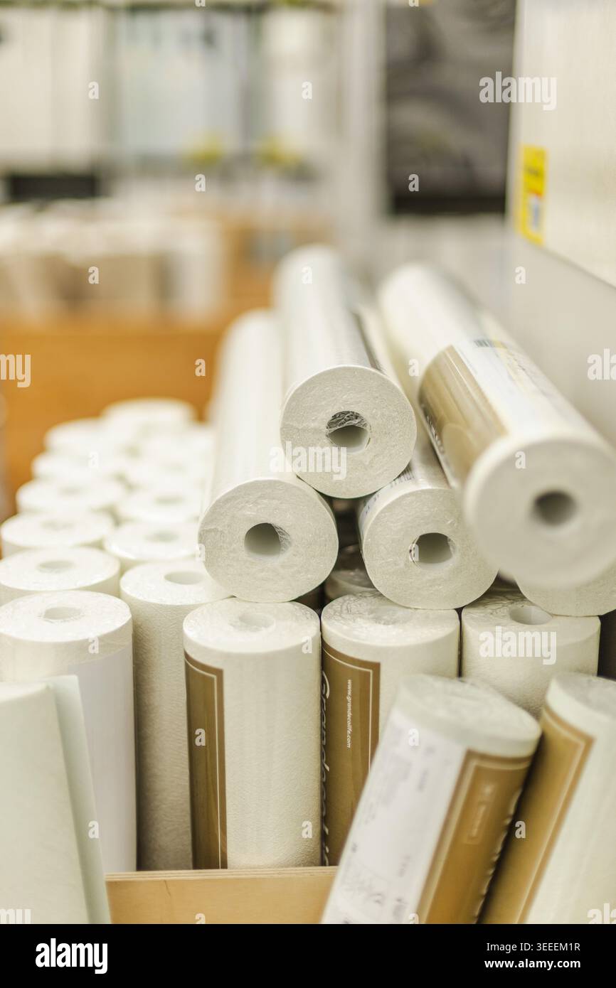 Vertikale Ansicht der weißen Tapetenrollen, die im Eisenwarengeschäft für Renovierungsarbeiten im Innenraum ausgestellt werden Stockfoto