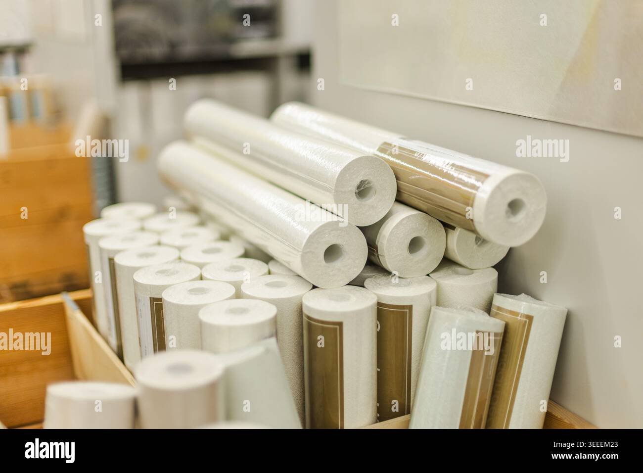 Gestapelte weiße Tapetenrollen und Renovierungsmaterialien im Inneren des Eisenwarengeschäfts Stockfoto