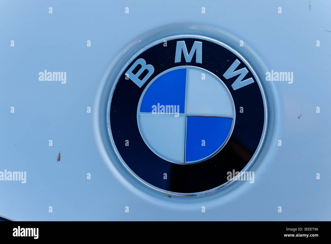 Autohemblem auf einer Fahrzeugkarosserie in blau-weißem Design mit Buchstaben Stockfoto