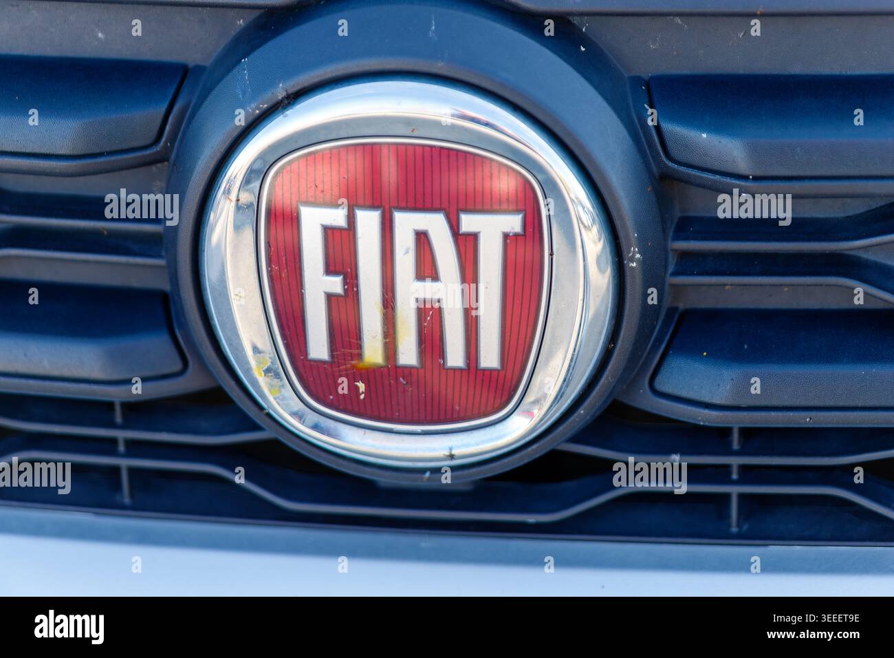 Kühlergrill mit einem roten und verchromten Emblem an einem Fahrzeug Stockfoto