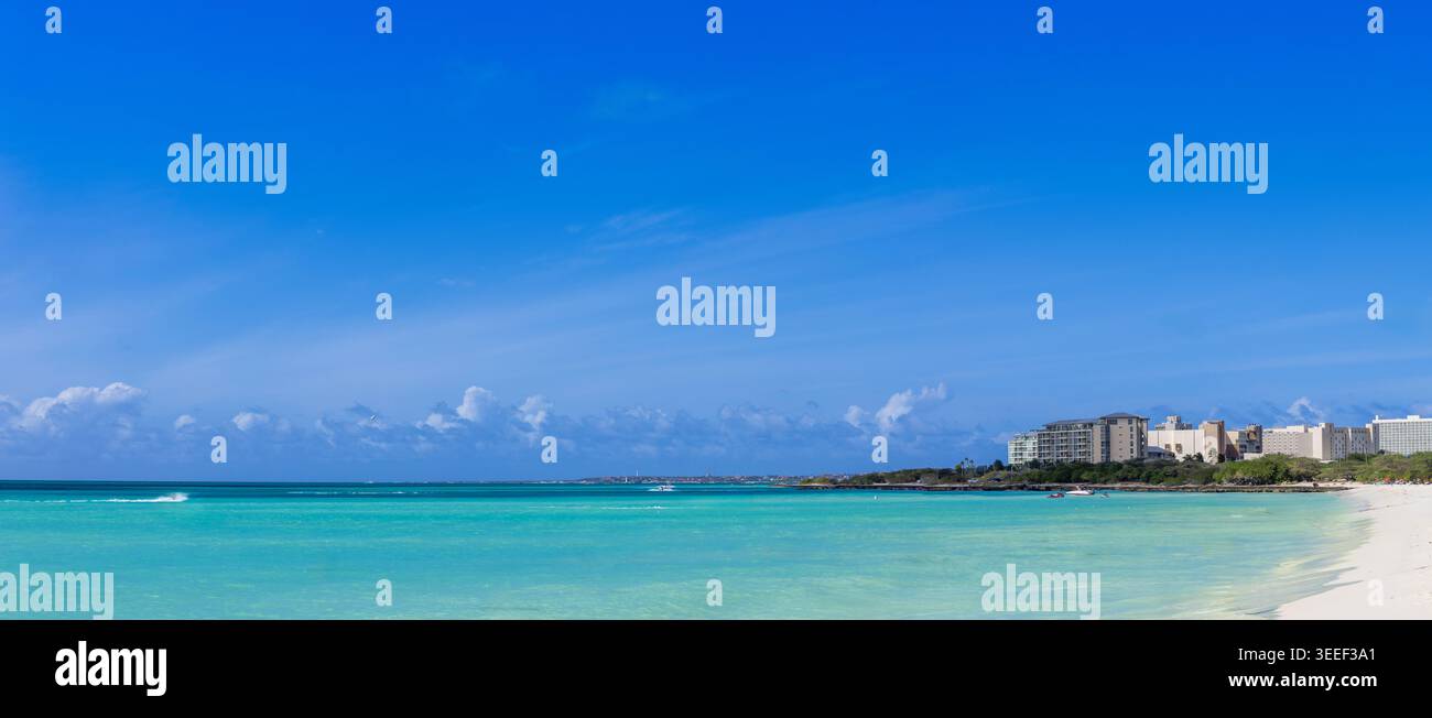 Panoramablick auf Eagle Beach in Aruba mit türkisfarbenem karibischem Wasser und weißer Sandküste mit tropischer Skyline unter einem klaren blau Stockfoto