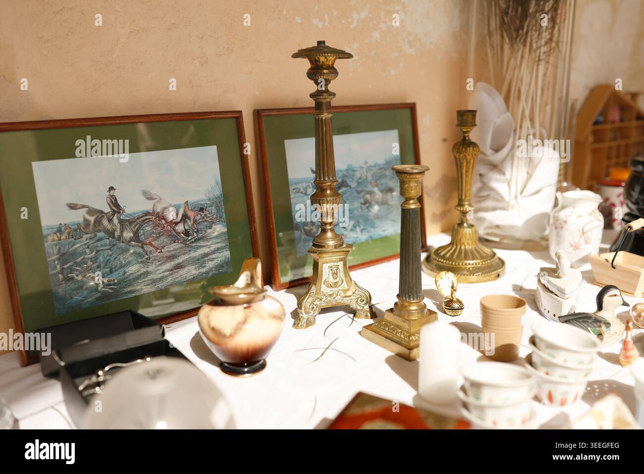 Antiker französischer Flohmarkt mit Messing-Kerzenleuchtern und gerahmten Jagddrucken. Traditionelles provenzalisches Brocante-Angebot von Vintage Stockfoto