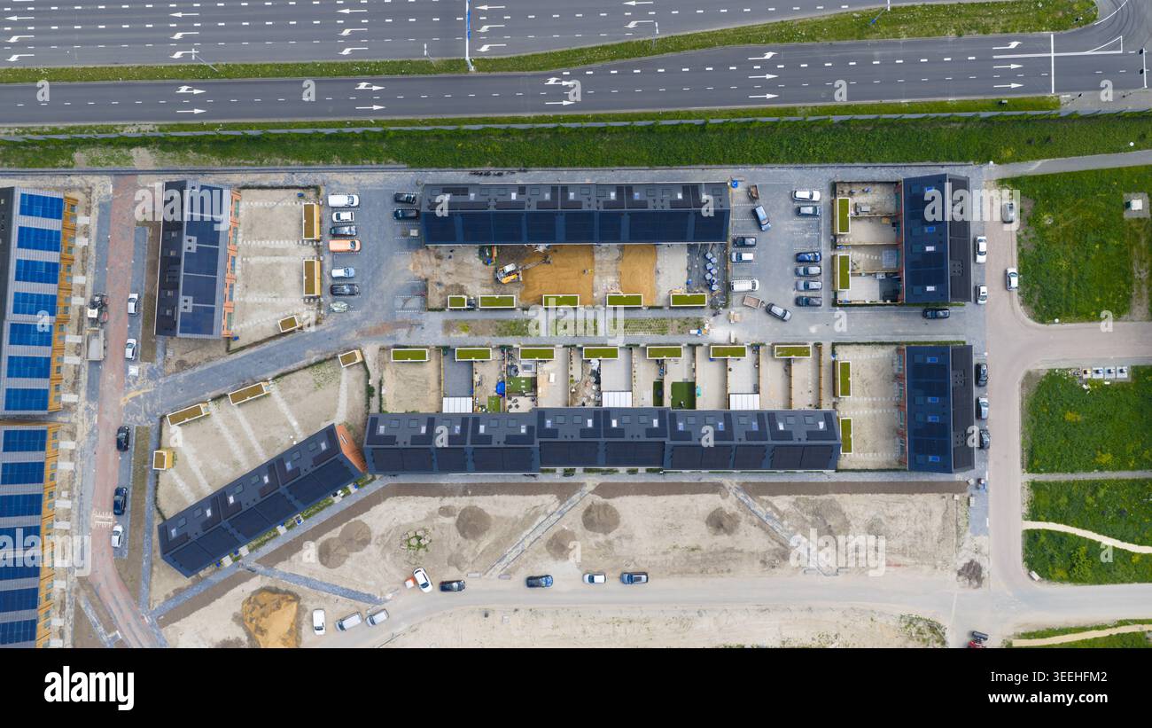 Luftaufnahme moderner Wohnhäuser mit Solarpaneelen auf Dächern und geparkten Autos in einer neuen Wohnsiedlung Utrecht, Utrecht, Niederlande. Stockfoto