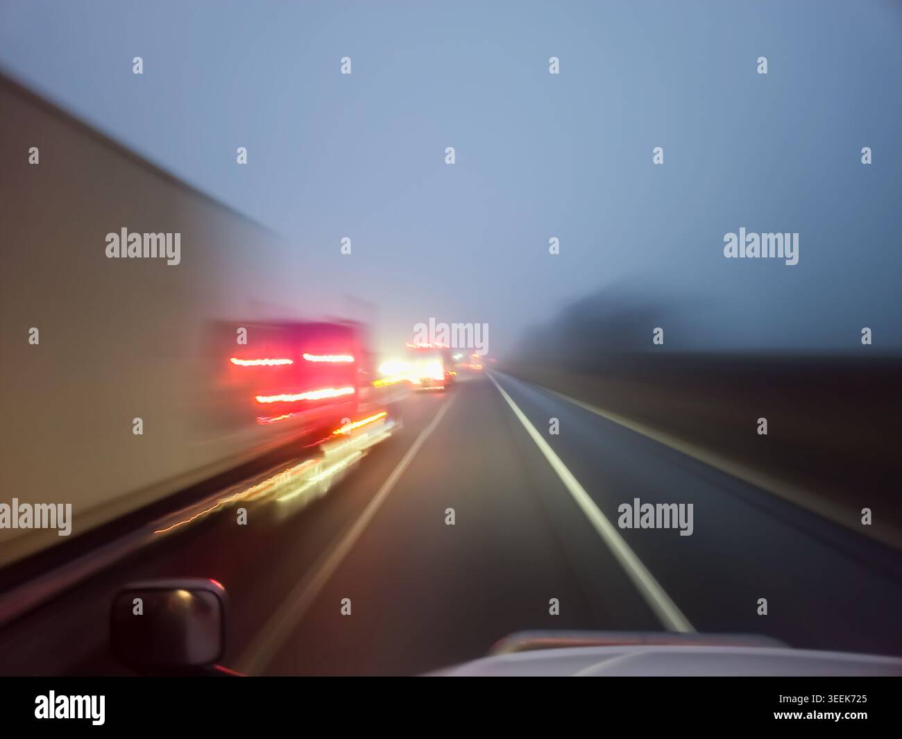 Autoscheinwerfer, die durch dicken Nebel auf Nachtstraßen leuchten, für professionelle Stau Stockfoto