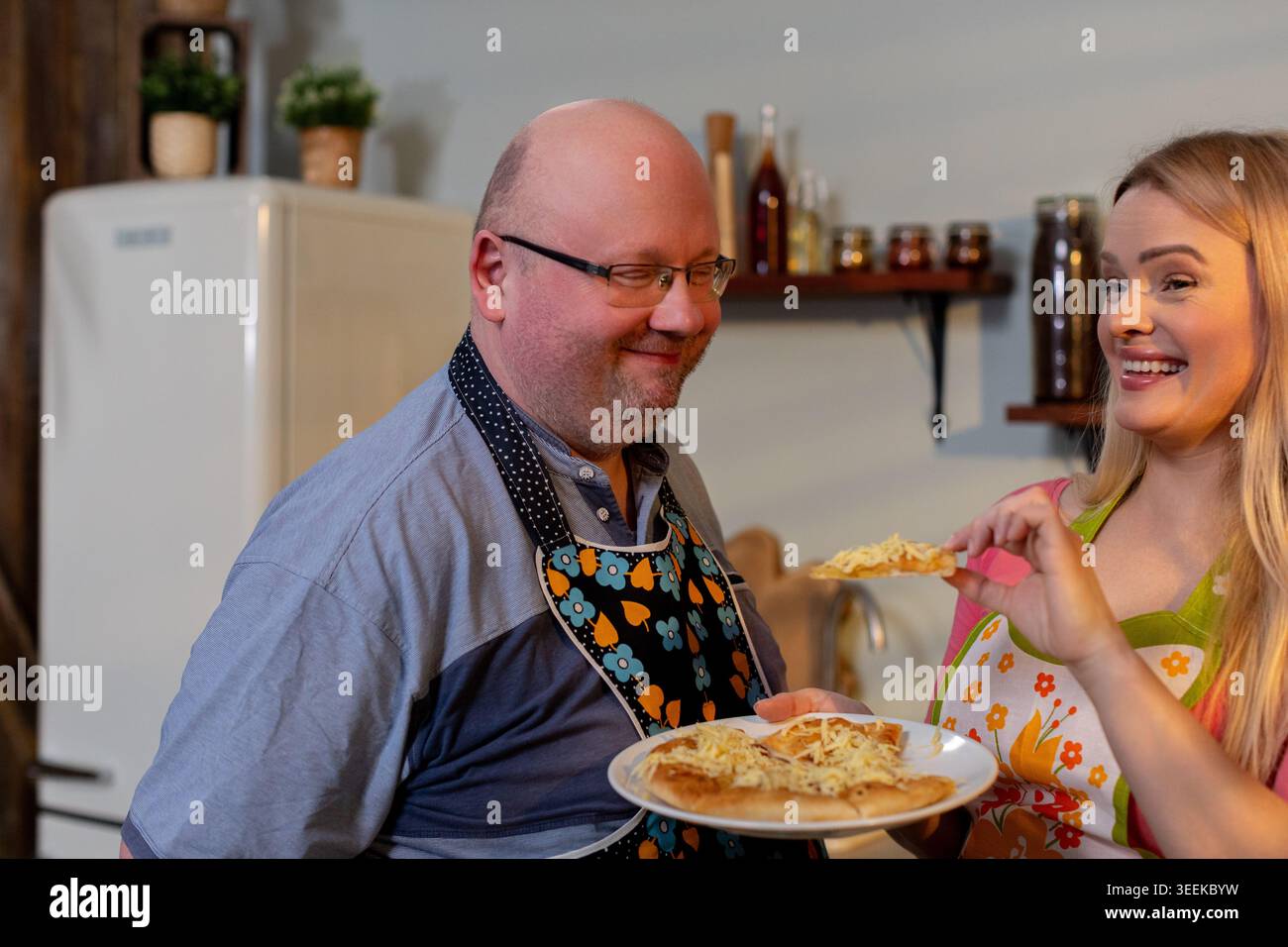 Paare genießen Pasta, romantische Duo-Köstlichkeiten in frisch zubereiteten Pasta in der Residenz, Paare von Enthusiasten schätzen die Freude an der Zubereitung und Verkostung Stockfoto