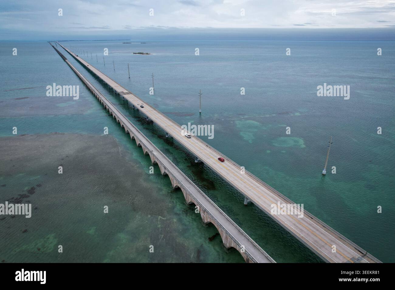 Aus der Vogelperspektive auf den Overseas Highway, der sich über türkisfarbenes Wasser erstreckt, mit Autos und der alten Brücke entlang in Key Largo, Florida, United St Stockfoto