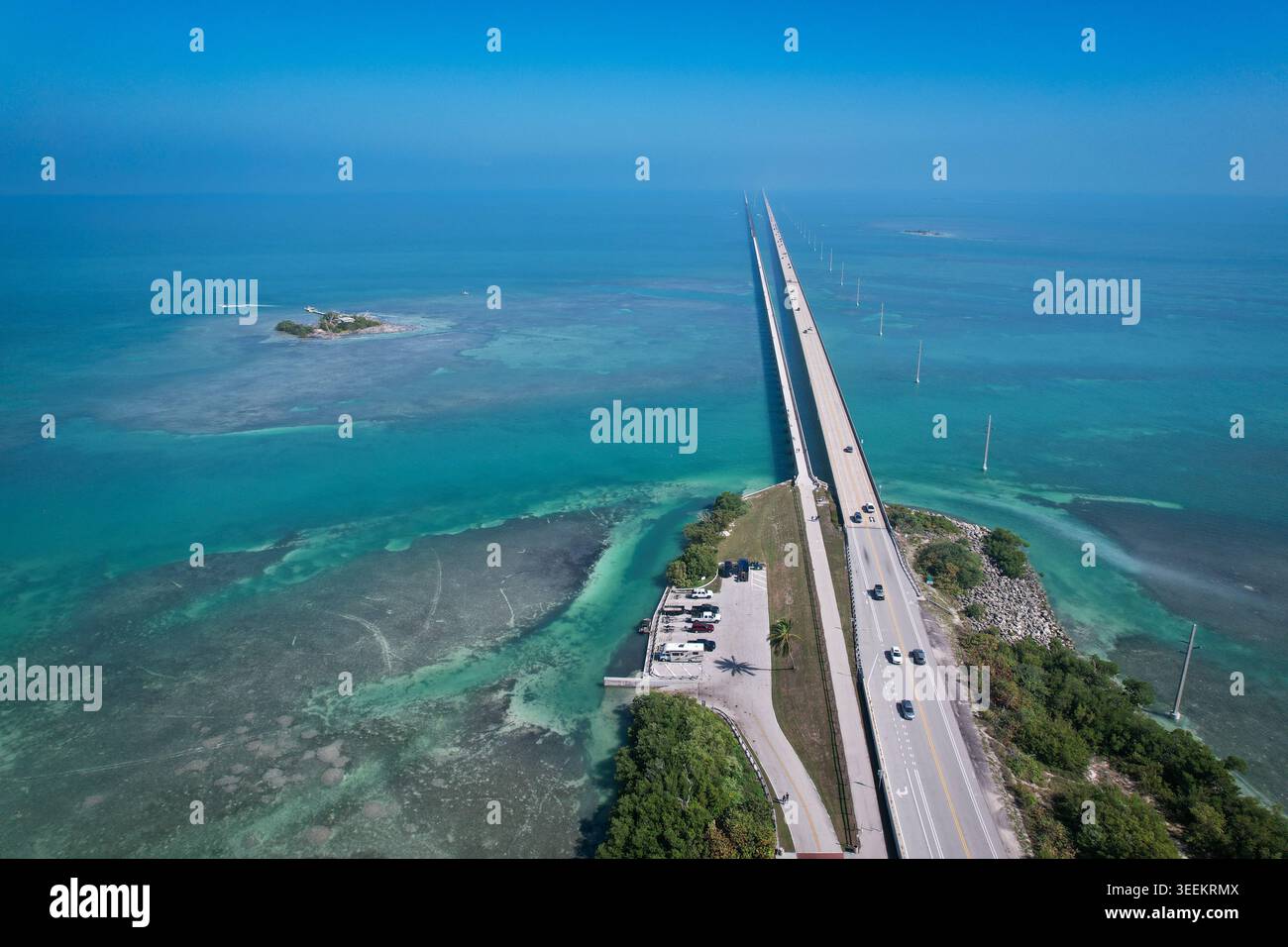 Aus der Vogelperspektive auf den Overseas Highway, der sich über türkisfarbenes Wasser und kleine Inseln unter einem klaren blauen Himmel erstreckt Key Largo, Florida, USA. Stockfoto