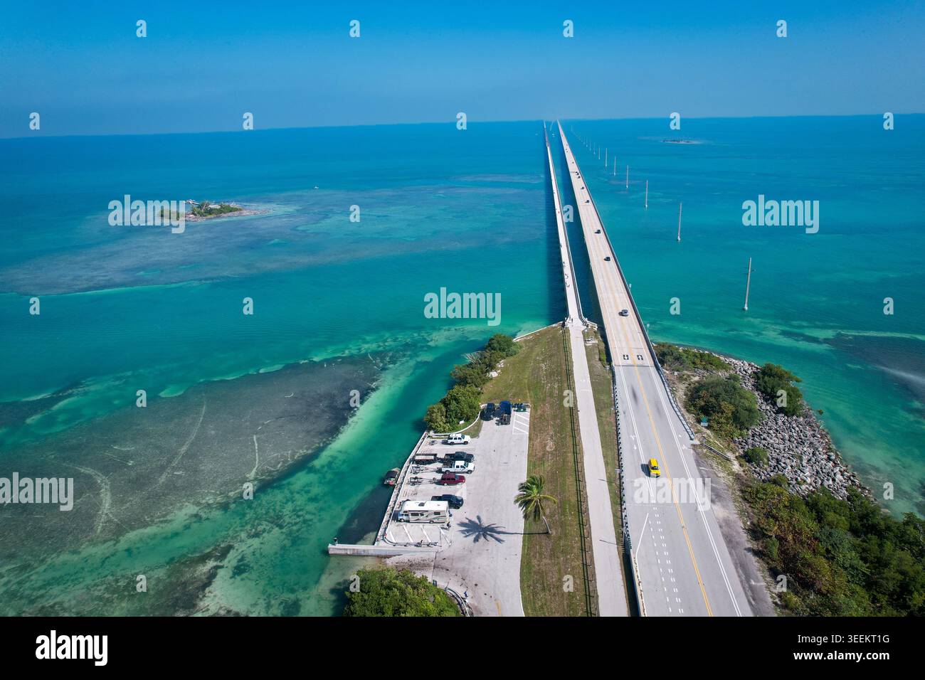 Aus der Vogelperspektive des Overseas Highway, der sich über türkisfarbenes Wasser und Korallenriffe unter einem klaren blauen Himmel in Key Largo, Florida, USA erstreckt. Stockfoto