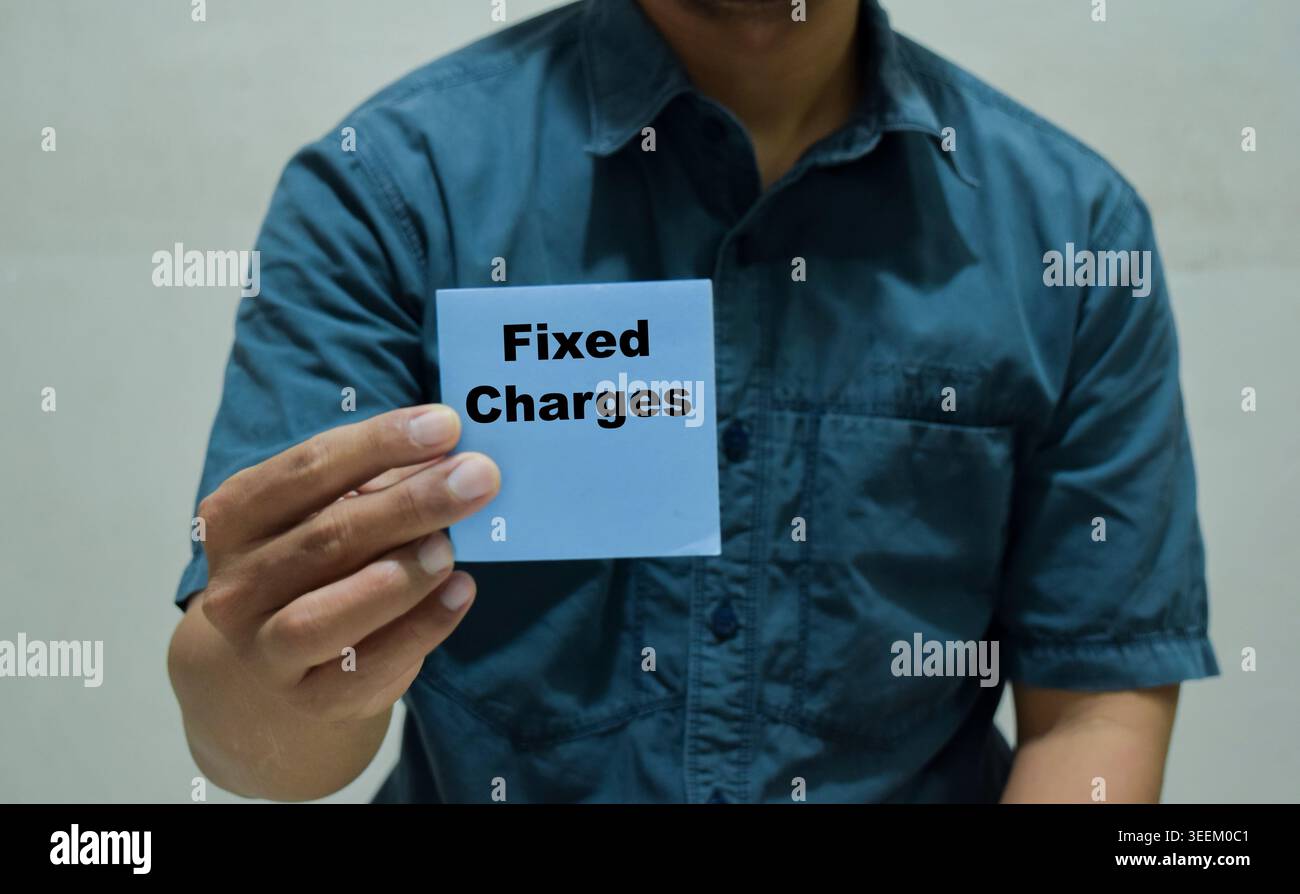 Der Geschäftsmann hält eine Karte mit dem Namen der festen Gebühren in Händen. Stockfoto