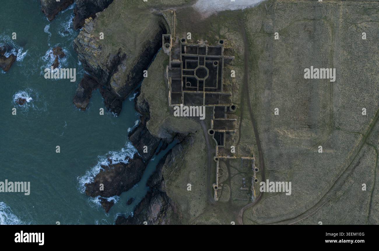 Blick aus der Vogelperspektive auf die historischen Ruinen von Slains Castle auf zerklüfteten Klippen mit Blick auf die dunklen Nordseewellen Cruden Bay, Schottland, Großbritannien. Stockfoto