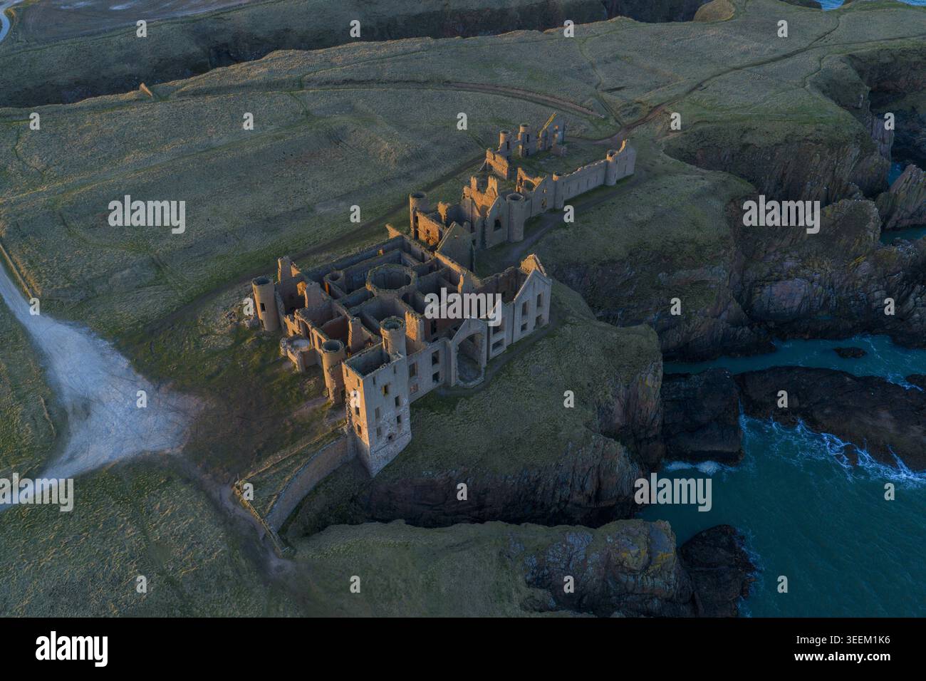 Aus der Vogelperspektive der Slains Castle Ruinen an den zerklüfteten Klippen der Nordseeküste während der goldenen Stunde Cruden Bay, Schottland, Großbritannien. Stockfoto