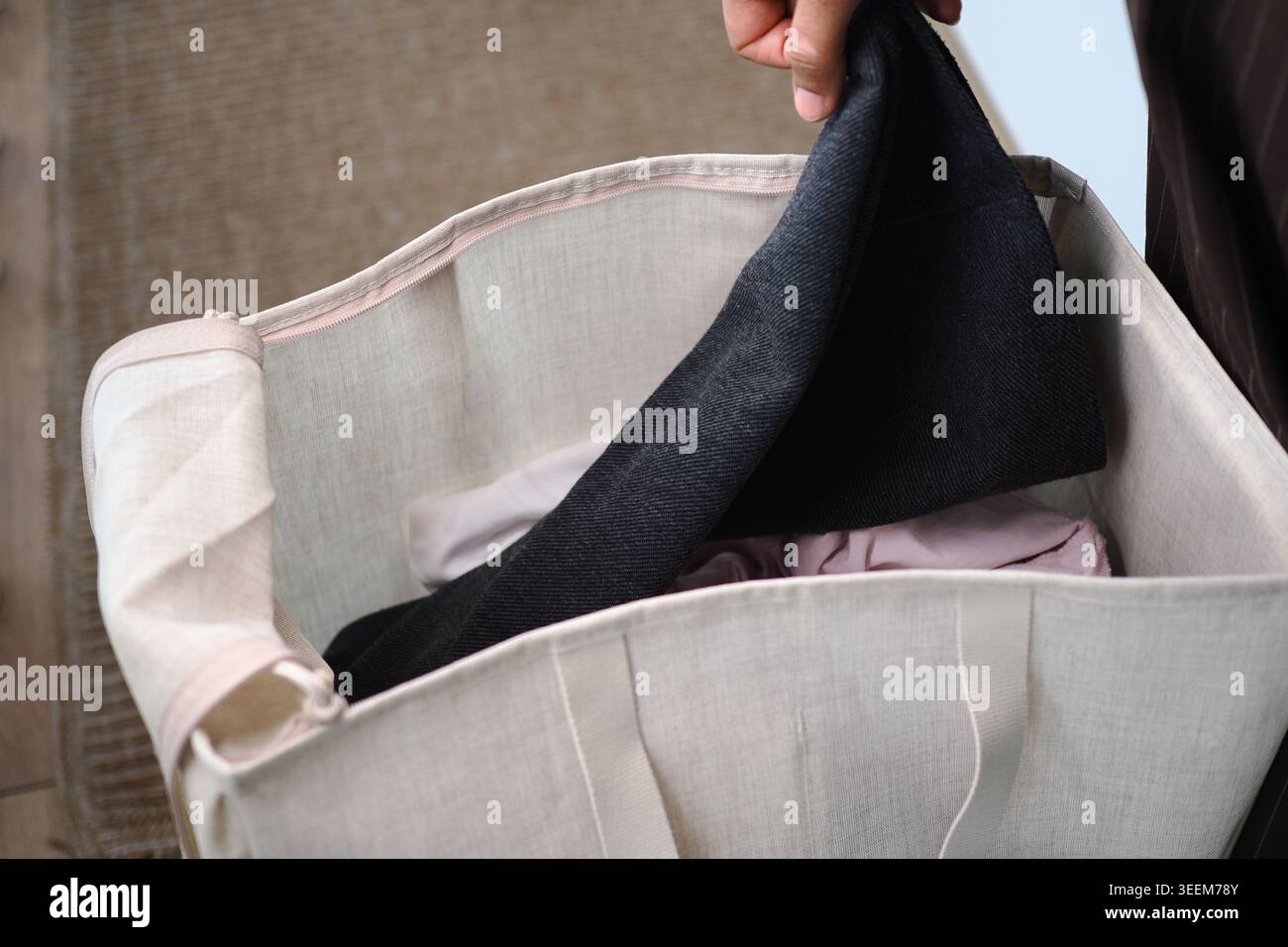 Person, die zu Hause Kleidung aus einer Stofftasche zieht Stockfoto