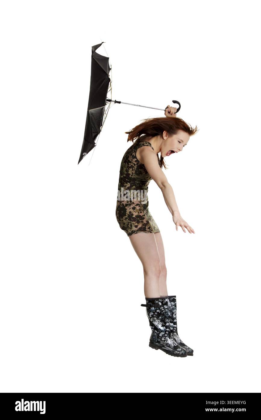 Junge Frau mit Regenschirm von Wind geblasen. Isoliert auf weißem backgroiund Stockfoto