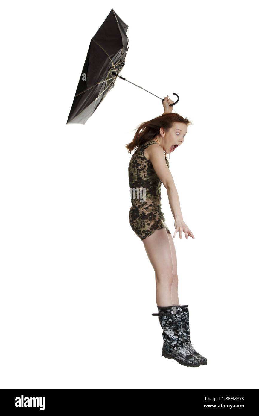Junge Frau mit Regenschirm von Wind geblasen. Isoliert auf weißem backgroiund Stockfoto