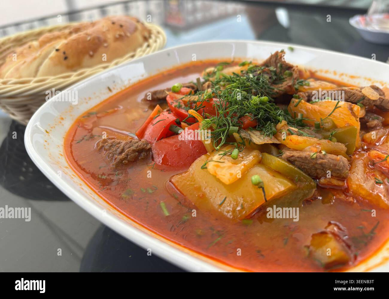 Chorba Lammsuppe, Shurpa im arabischen Restaurant. Kasachische Mahlzeit mit Fleisch, Gewürzen, Gemüse und Gemüse in weißer Schüssel Nahaufnahme Stockfoto