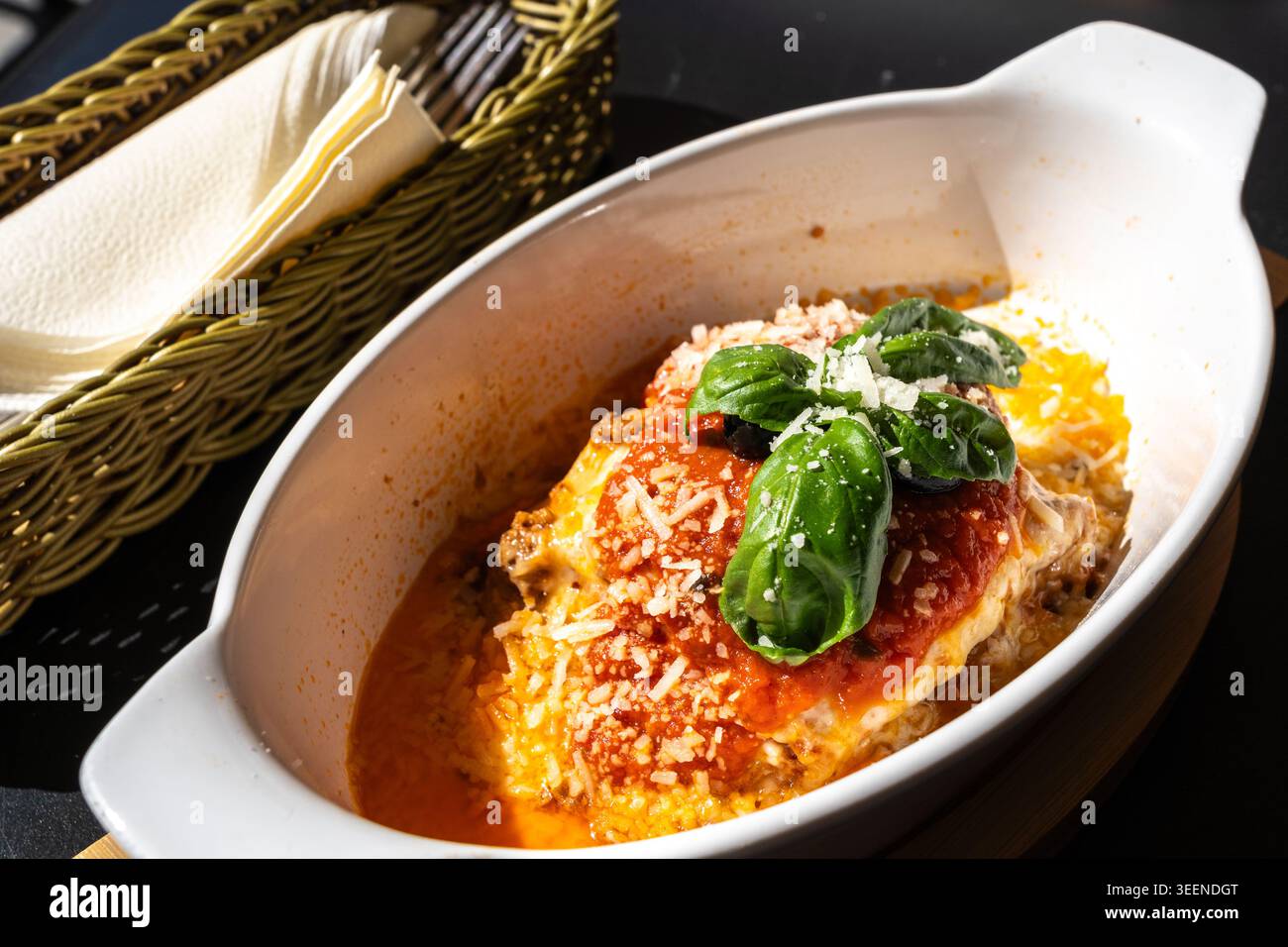 Lasagne Portion, im Ofen gebackene Lasagne, Nudelschichten mit Käse, Hackfleisch, Tomaten. Lasagne am Tisch des Straßenrestaurants an einem sonnigen Sommertag, verschwommen Stockfoto