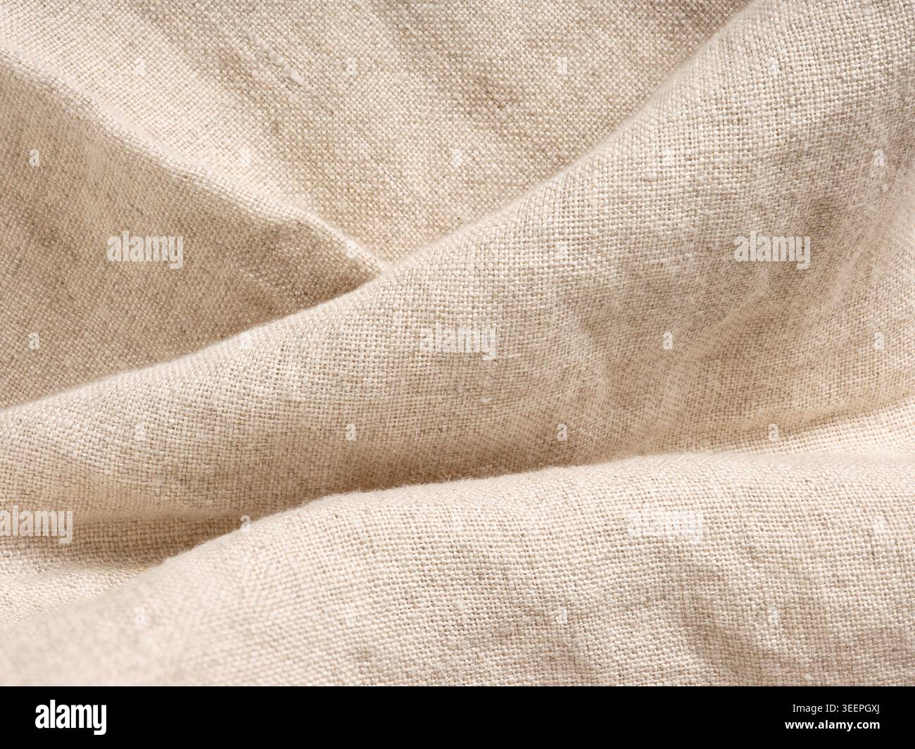Naturbeige Leinengewebe mit gewebter Textur und subtilen Falten, perfekt für Textil- und organische Materialkonzepte Stockfoto