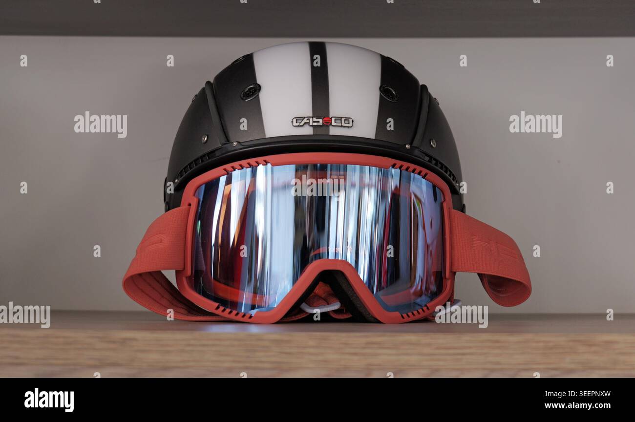 Schwarz-weißer Skihelm in Kombination mit einer rot gerahmten Schutzbrille bietet einen wichtigen Kopf- und Augenschutz für verschiedene Wintersportaktivitäten Stockfoto