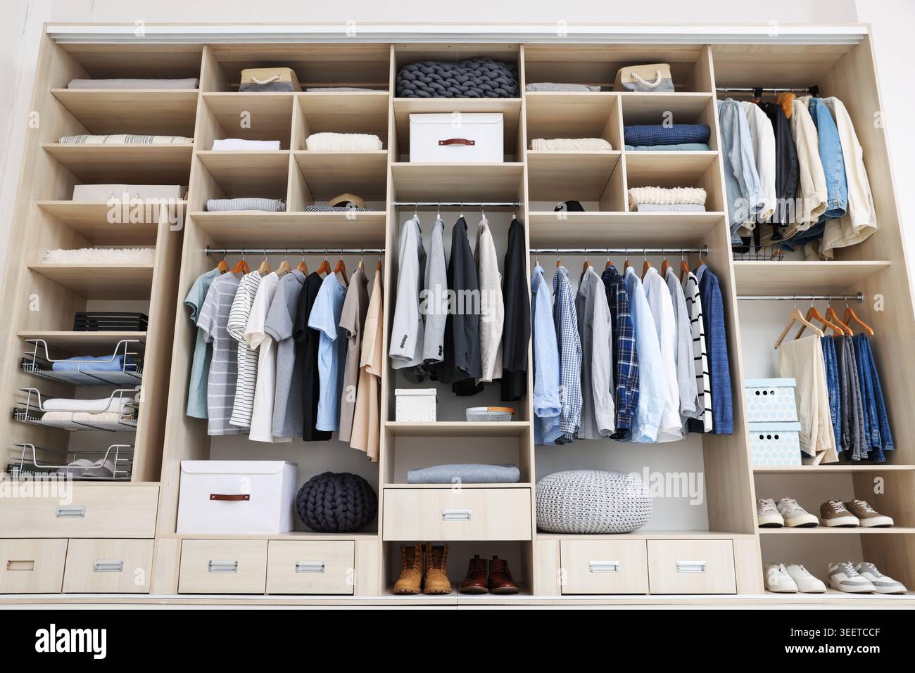 Kleiderschrank mit verschiedenen stilvollen Kleidungsstücken, Accessoires, Schuhen und Haushaltsgegenständen im Innenbereich, geringer Blickwinkel Stockfoto