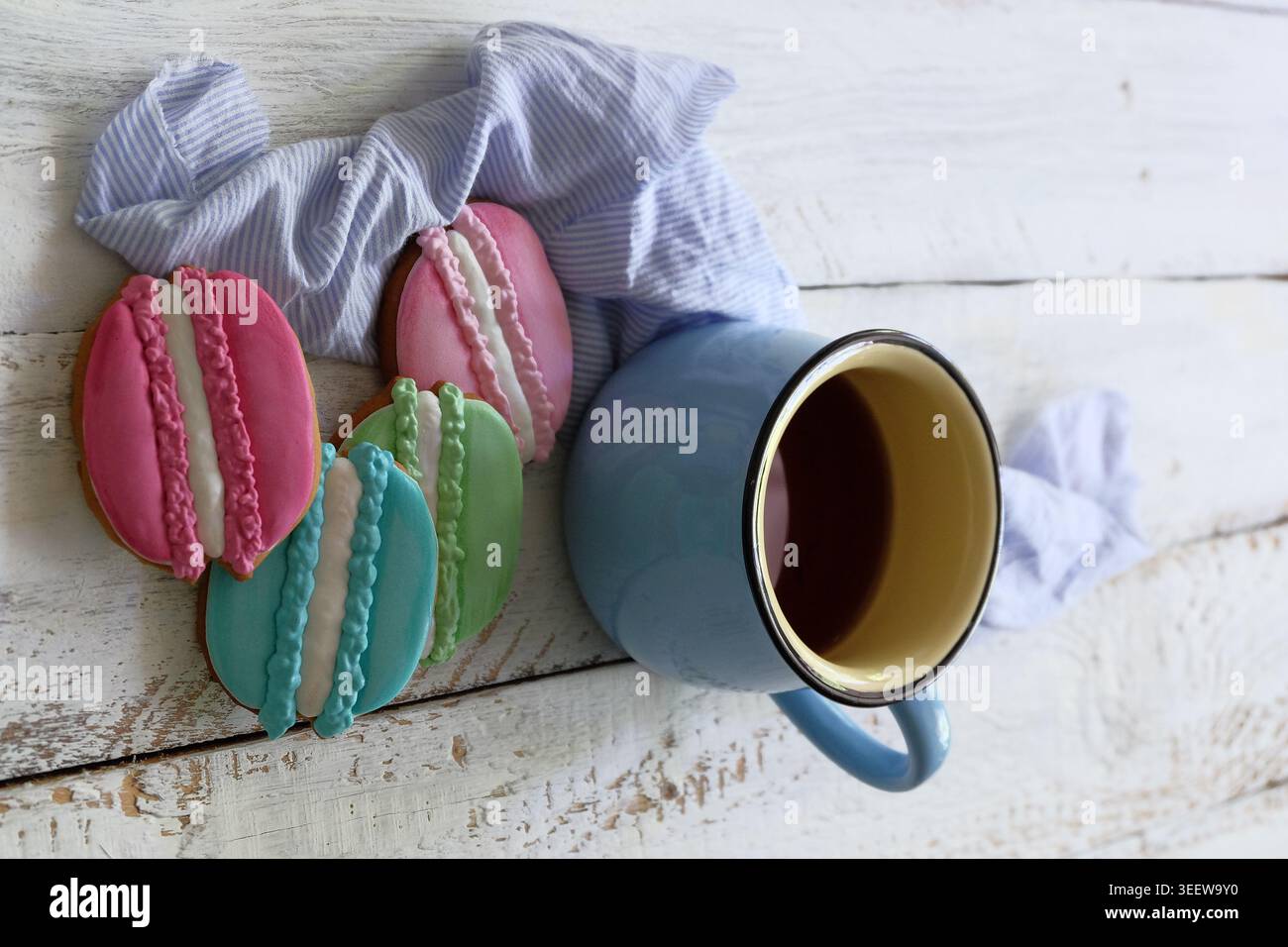 Bezaubernde Pastell-Macarons und dampfender Kaffee bei Tageslicht Stockfoto