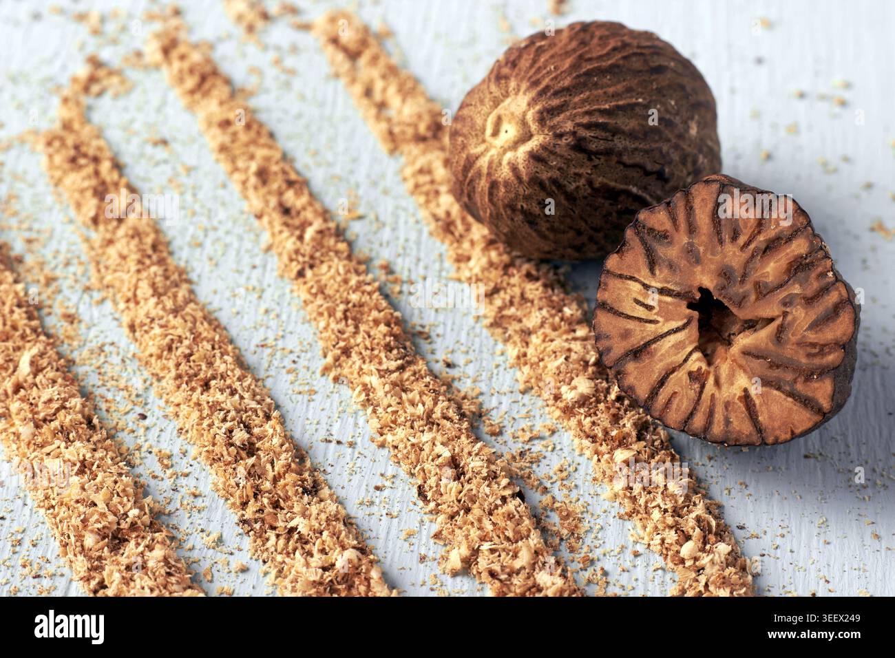 Muskatnuss und Muskatpulver auf einem hellblauen Holztisch Stockfoto