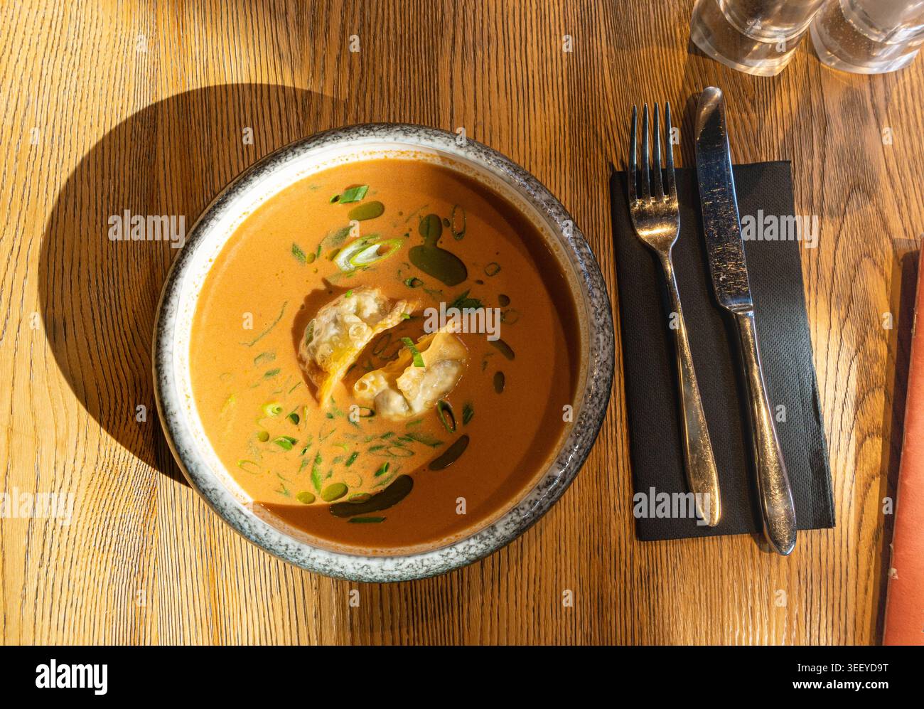 Nepalesische Momo Jhol Achar Knödelsuppe, gebratene Gyoza-Brühe, scharfe Tomaten-Momo-Suppe in exquisitem Restaurant Bowl im Sonnenlicht Closeup Stockfoto
