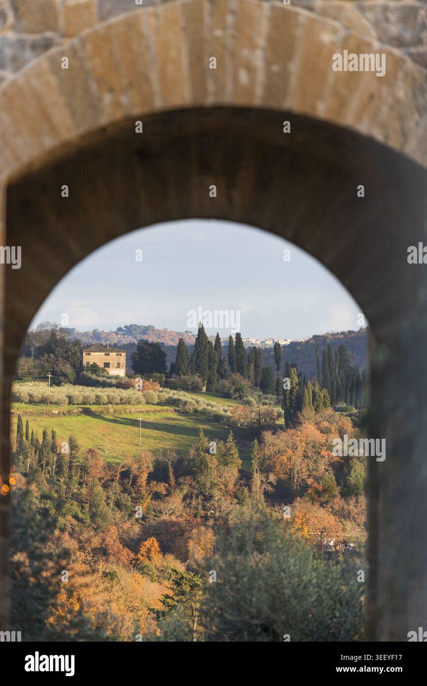 Blick auf die sanften Hügel und Zypressen der toskanischen Landschaft, eingerahmt von einem Steinbogen Monteriggioni, Toskana, Italien. Stockfoto