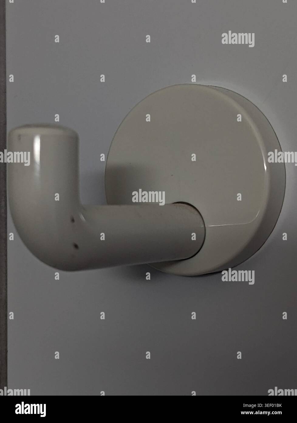 Minimalistischer Wandhaken In Grau, Matte Oberfläche Mit Weichem Schatten, Geschwungener Arm Und Runde Montageplatte, Dezente Textur Und Glatte Oberfläche, Inszeniert Von Stockfoto