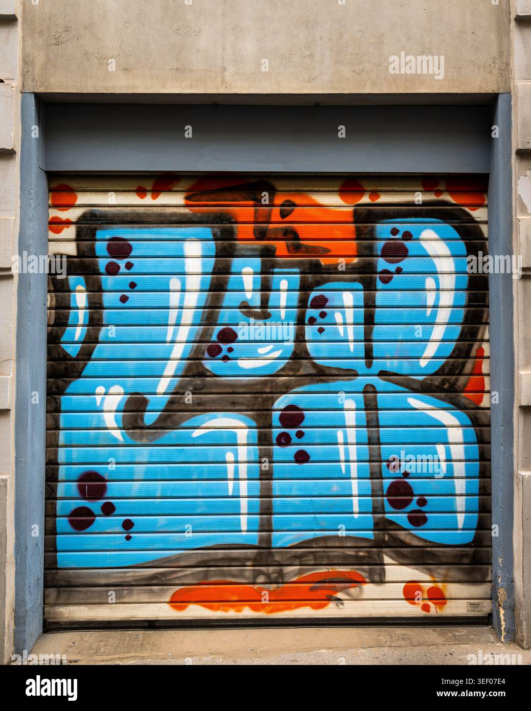 Wien, Österreich - 4. August 2020: Graffiti-Tag mit leuchtendem himmelblauem Bubble-Schriftzug mit roten Tropfen und weißen Highlights bedeckt einen Rollladen aus Metall Stockfoto