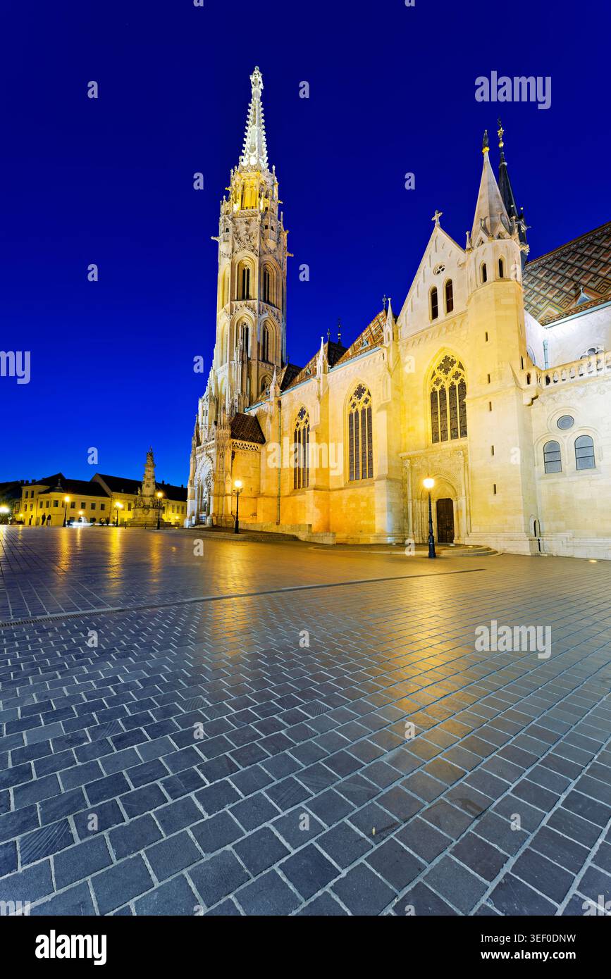 Die Matthiaskirche steht im Abendlicht in Budapest, Ungarn. Der Himmel zeigt tiefe Farben, wenn der Tag in die Nacht verwandelt wird. Stockfoto