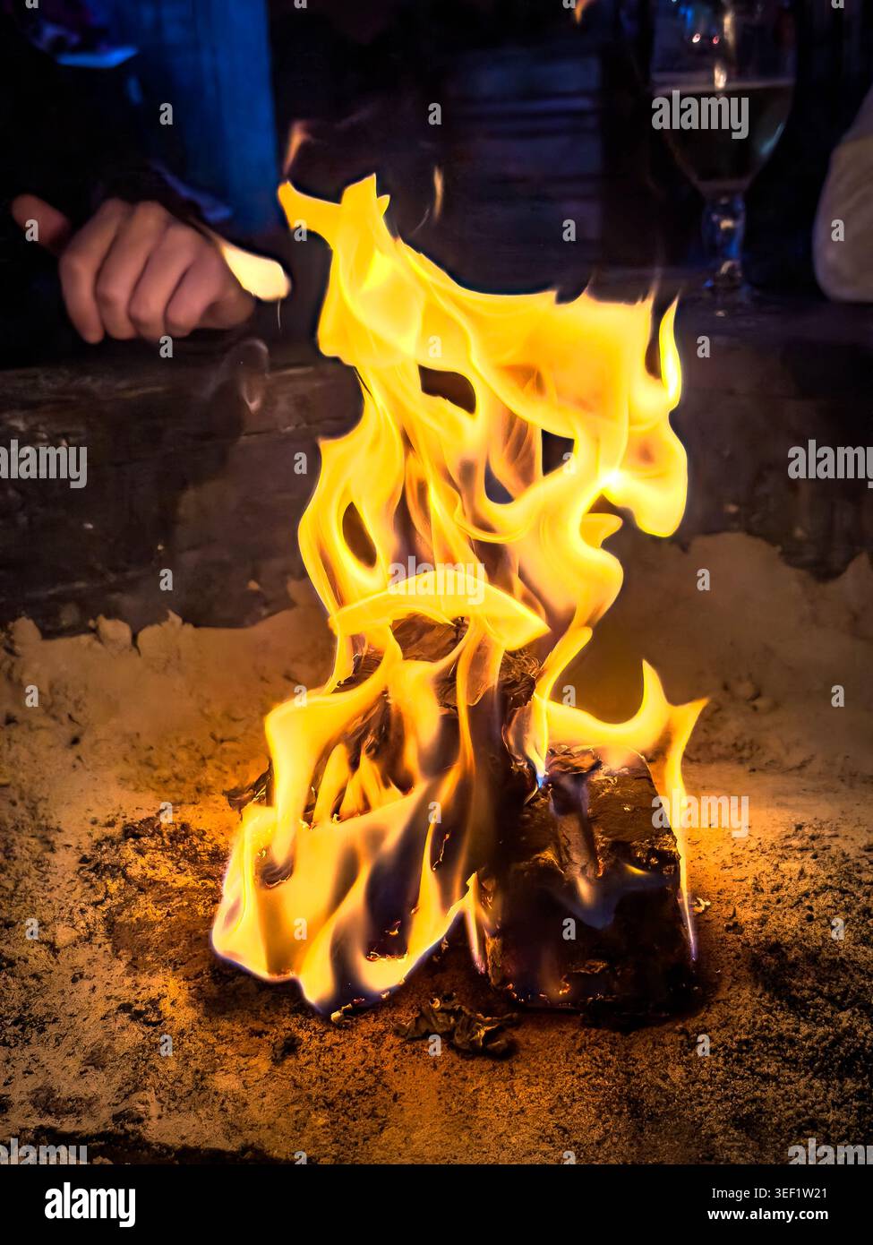 Nahaufnahme von leuchtend orangefarbenen und gelben Flammen, die in einer Feuerstelle im Freien brennen Stockfoto