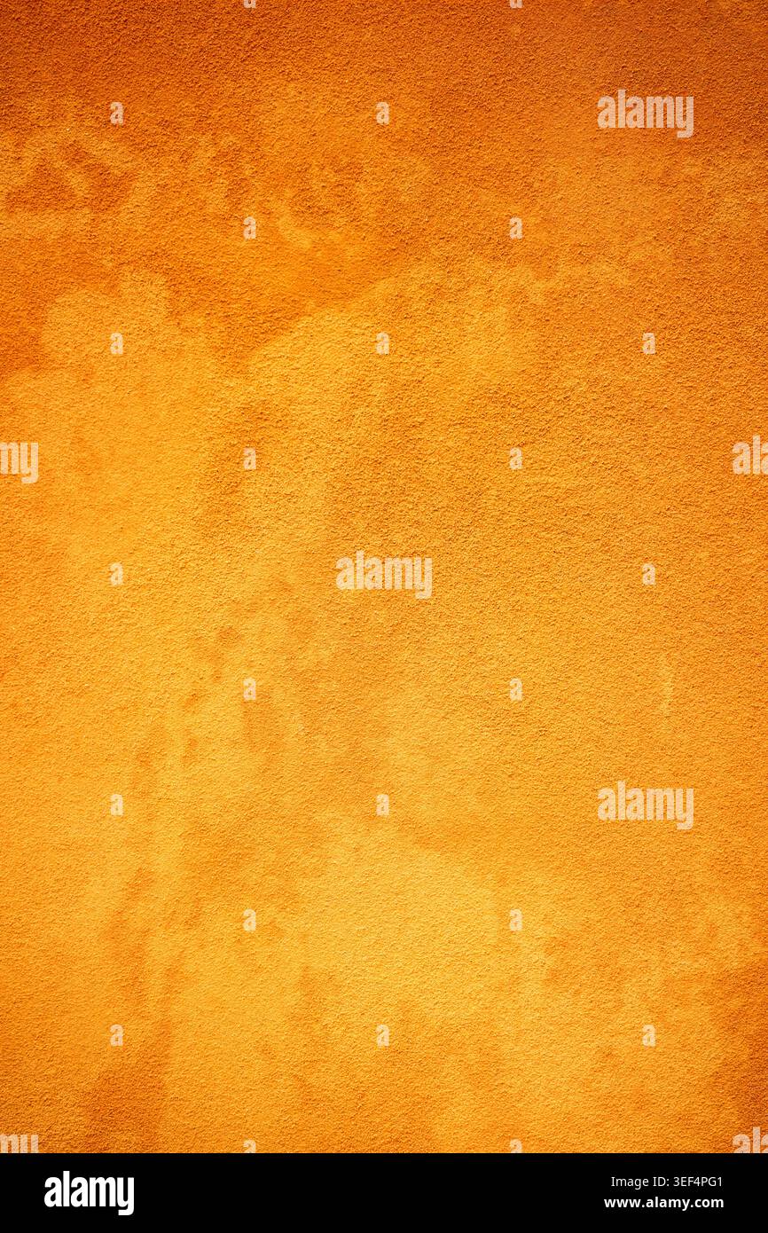 Eine Stuckwand mit tiefen orangefarbenen und gelben Farben – Hintergrundfotografie Stockfoto