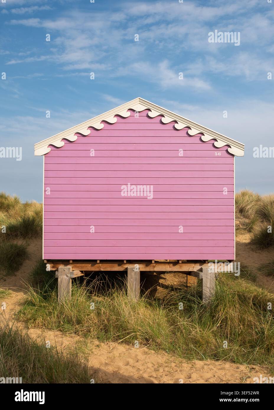 Eine pinkfarbene Strandhütte mit weißen Zierleisten in Hunstanton, Norfolk, England Stockfoto