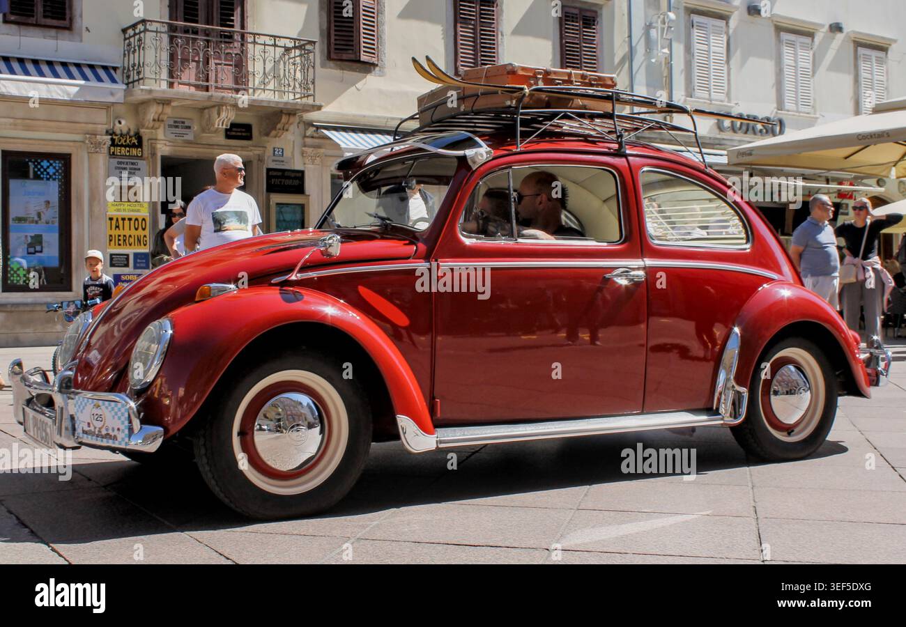 Klassischer roter Volkswagen-Käfer mit Vintage-Gepäck und Skiern auf dem Dach bei der 30. Internationalen Oldtimer-Auto-Rallye in Rijeka, 2. Mai 2026. Stockfoto